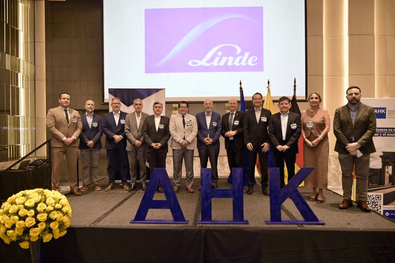 Un grupo de personas posando en un evento con fondos de las marcas Linde y AHK.