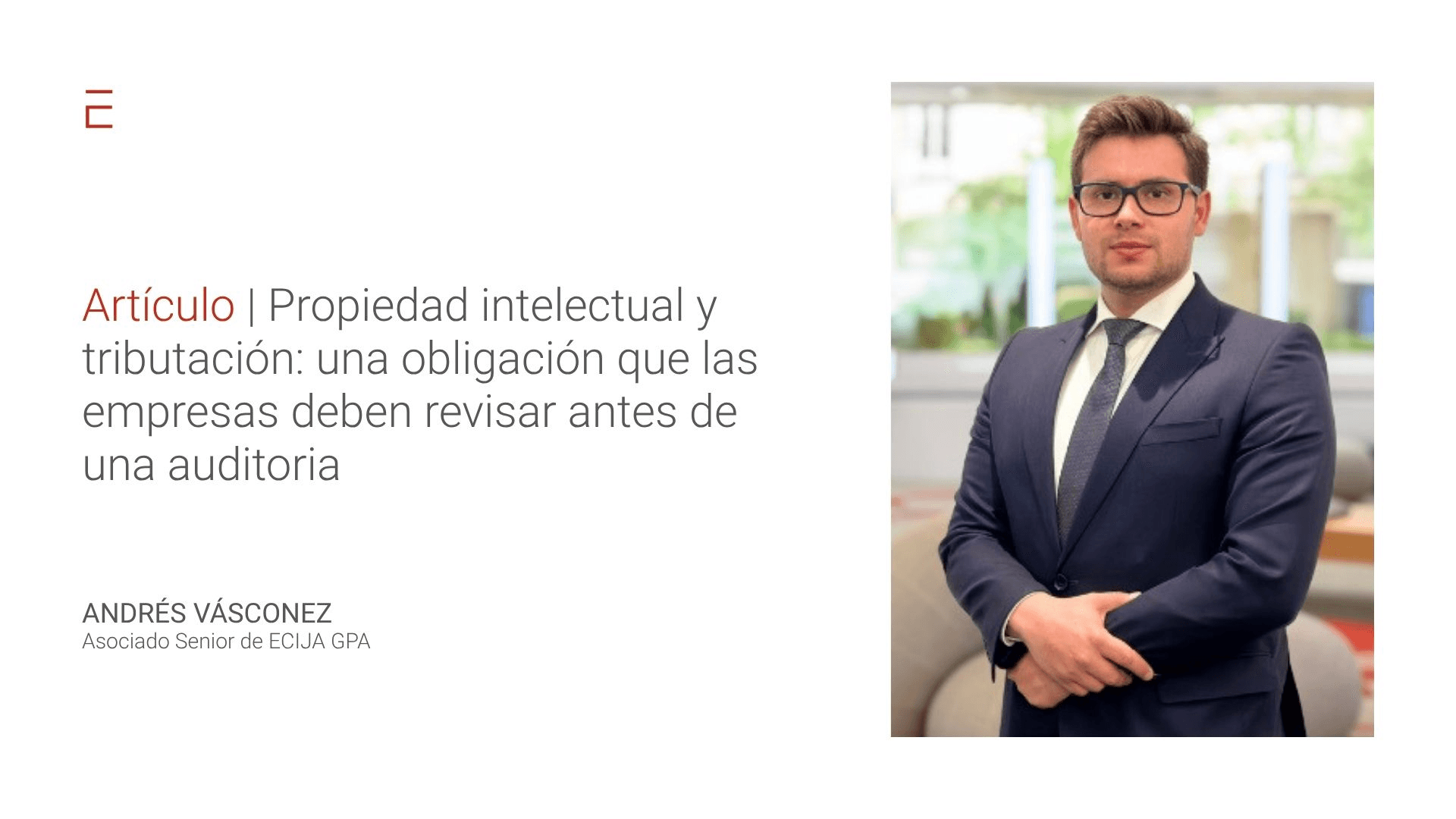 Un hombre con un traje formal posando en un entorno de oficina.