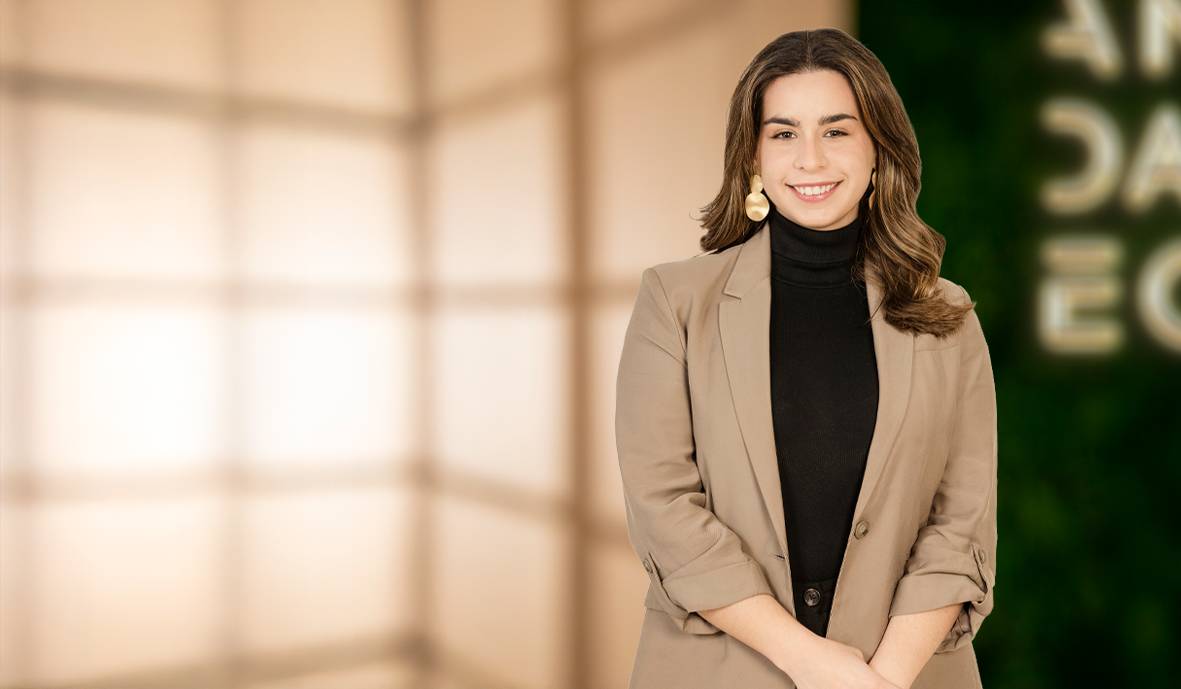 Mujer sonriente con un atuendo elegante en un ambiente moderno.