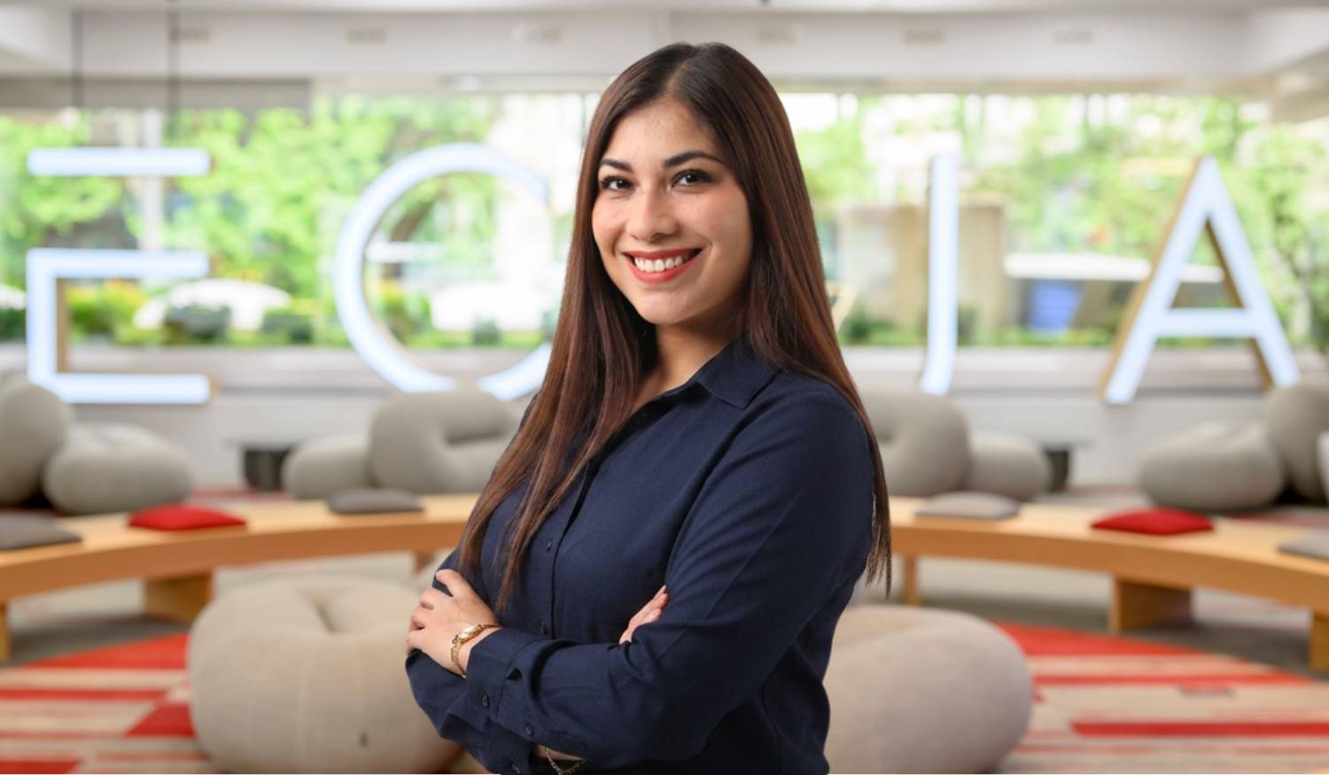 Una mujer sonriente posando en un entorno moderno y acogedor.
