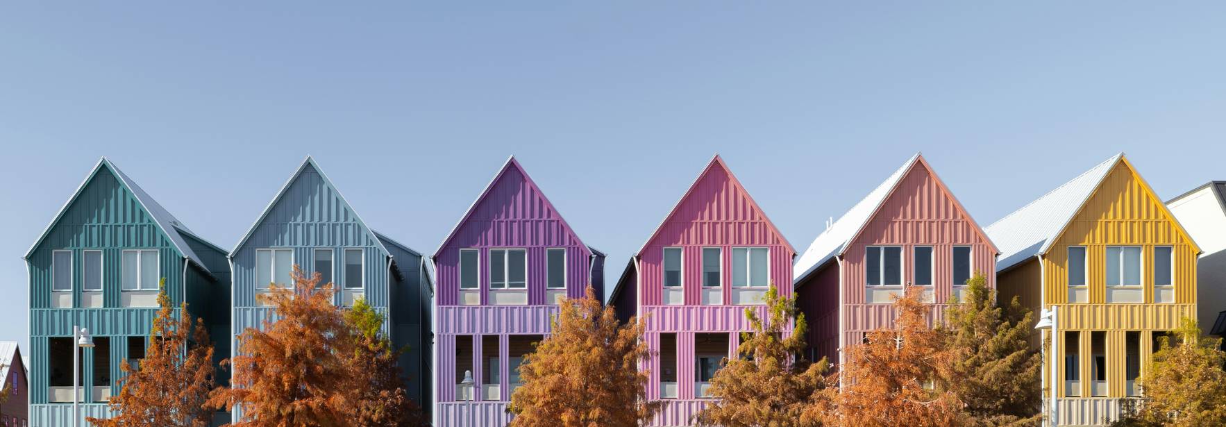 Una fila de casas coloridas frente a un cielo despejado.