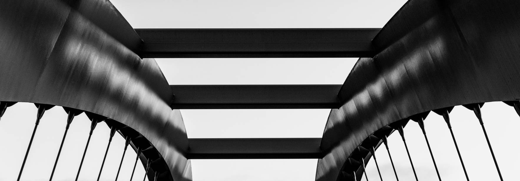 Estructura de un puente moderno en tonos de blanco y negro.
