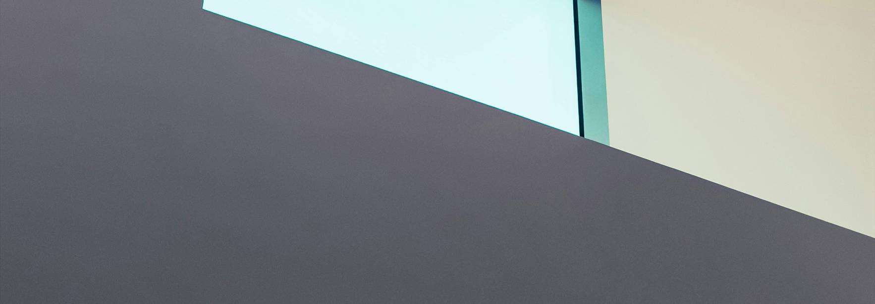 La imagen muestra una estructura arquitectónica moderna con líneas limpias y luz natural que entra a través de ventanas y aberturas.