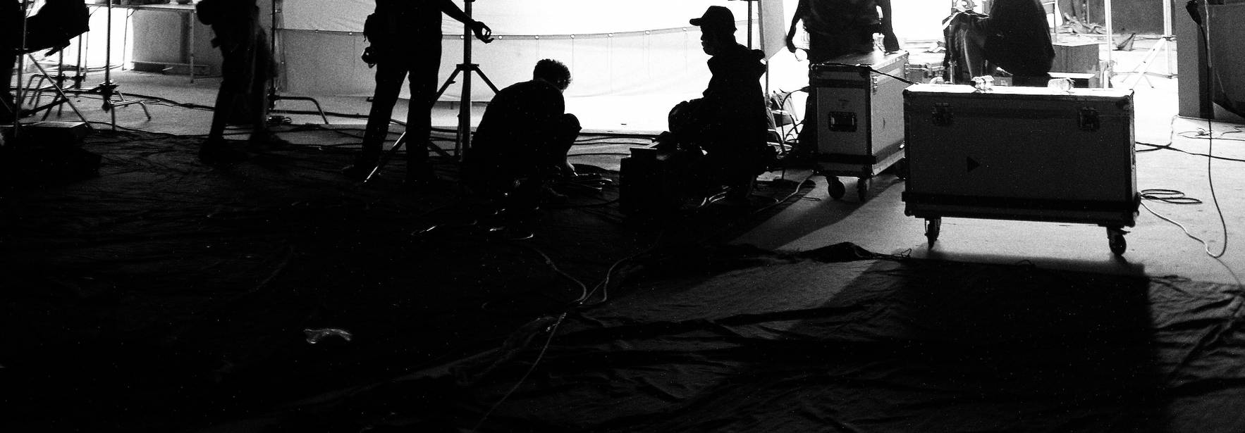 Una escena en blanco y negro de un set de filmación con varias personas trabajando.