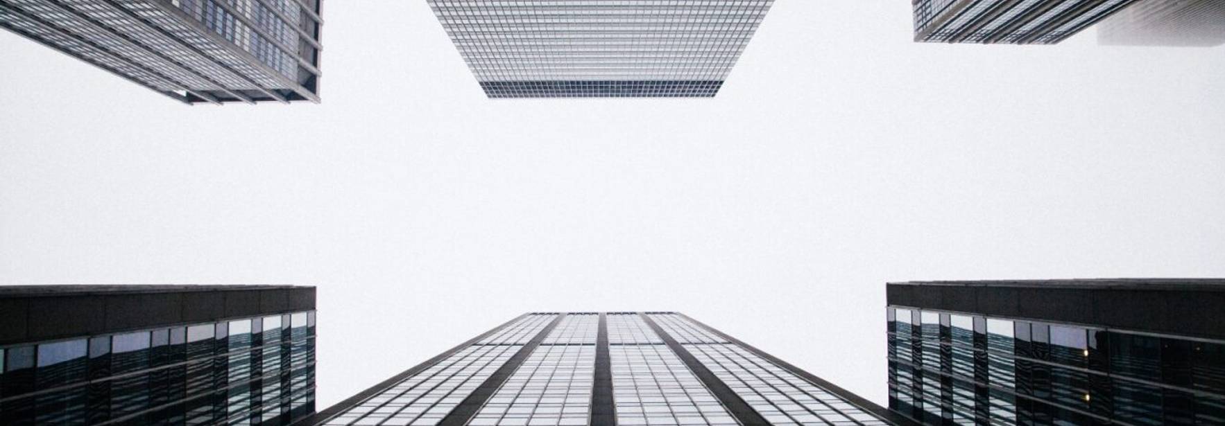 Vista desde abajo de edificios modernos que se elevan hacia el cielo.