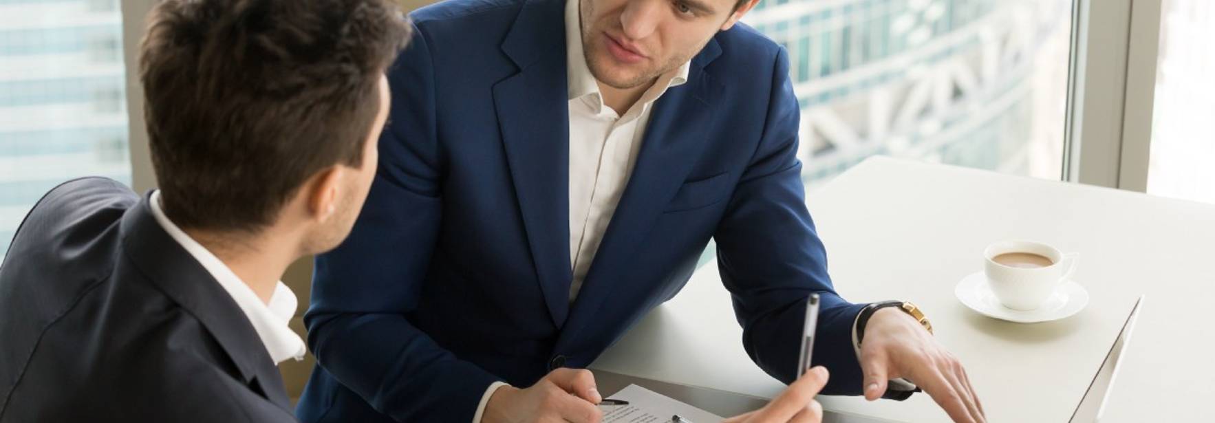 Dos profesionales se reúnen para analizar datos y gráficos en una oficina moderna.