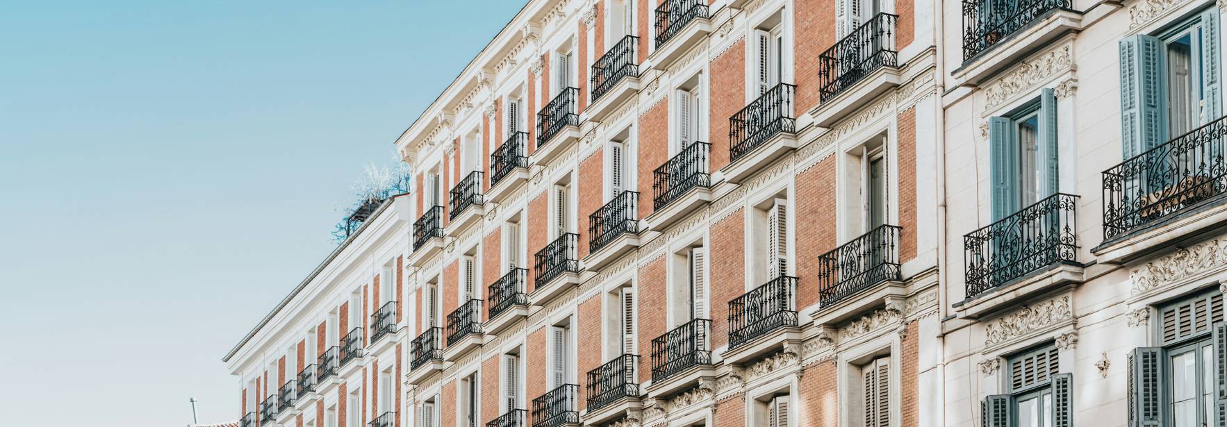 Una vista de un edificio con balcones y ventanas en un día despejado.