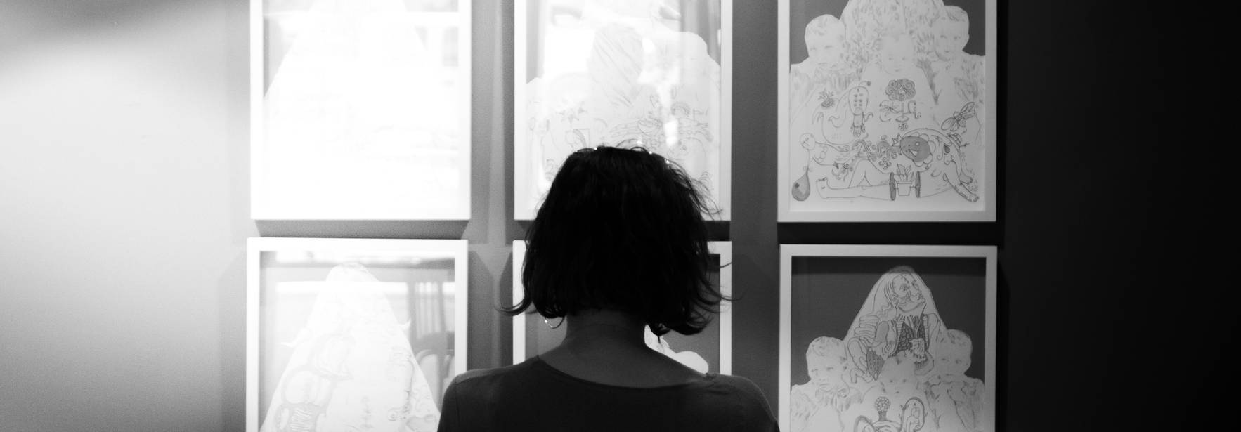 Una persona observa cuadros en una galería de arte.