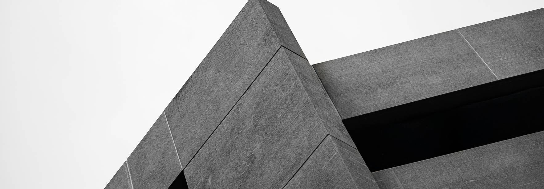Una estructura arquitectónica moderna con ángulos marcados y una paleta de colores en blanco y negro.