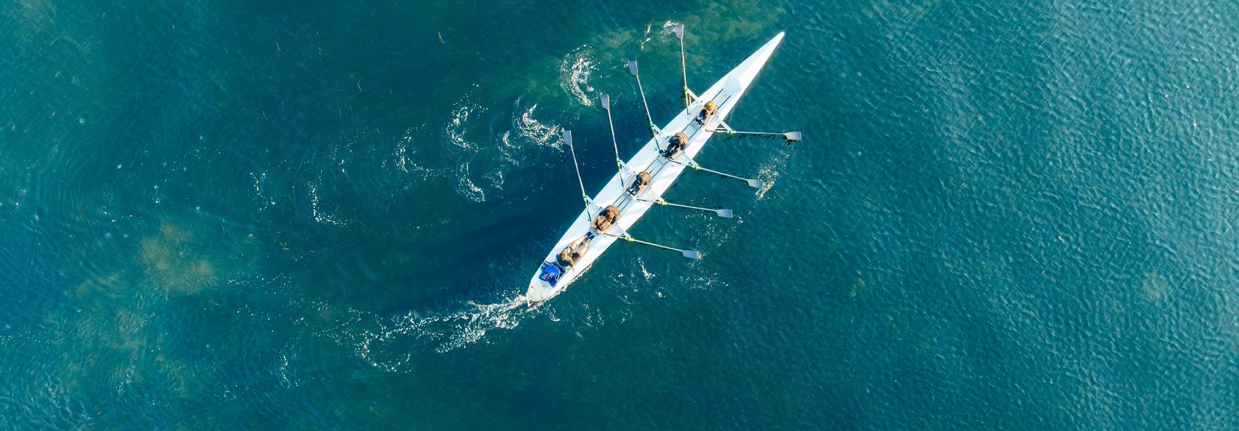 Una vista aérea de un bote de remo en una tranquila surface de agua.