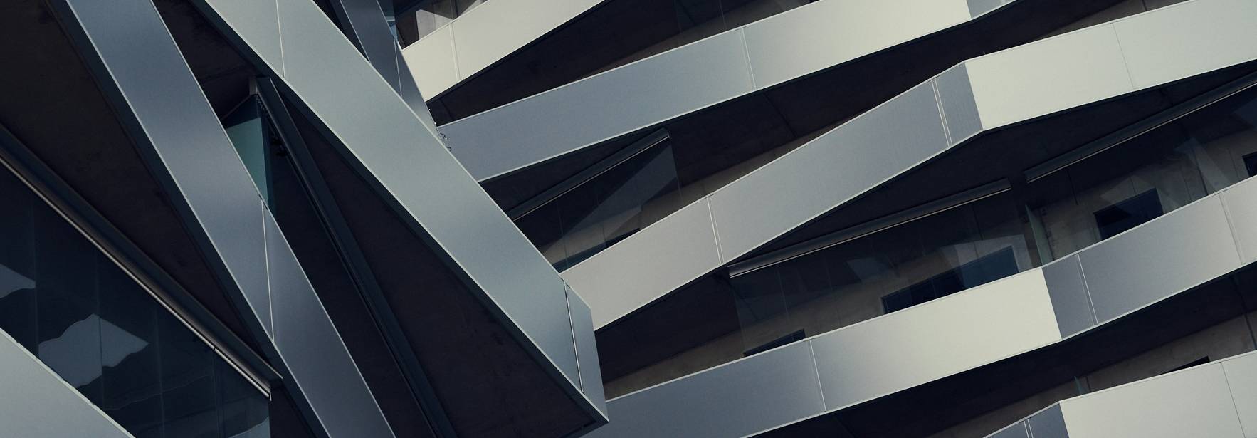 Una fachada moderna con un diseño arquitectónico de líneas diagonales y materiales metálicos.