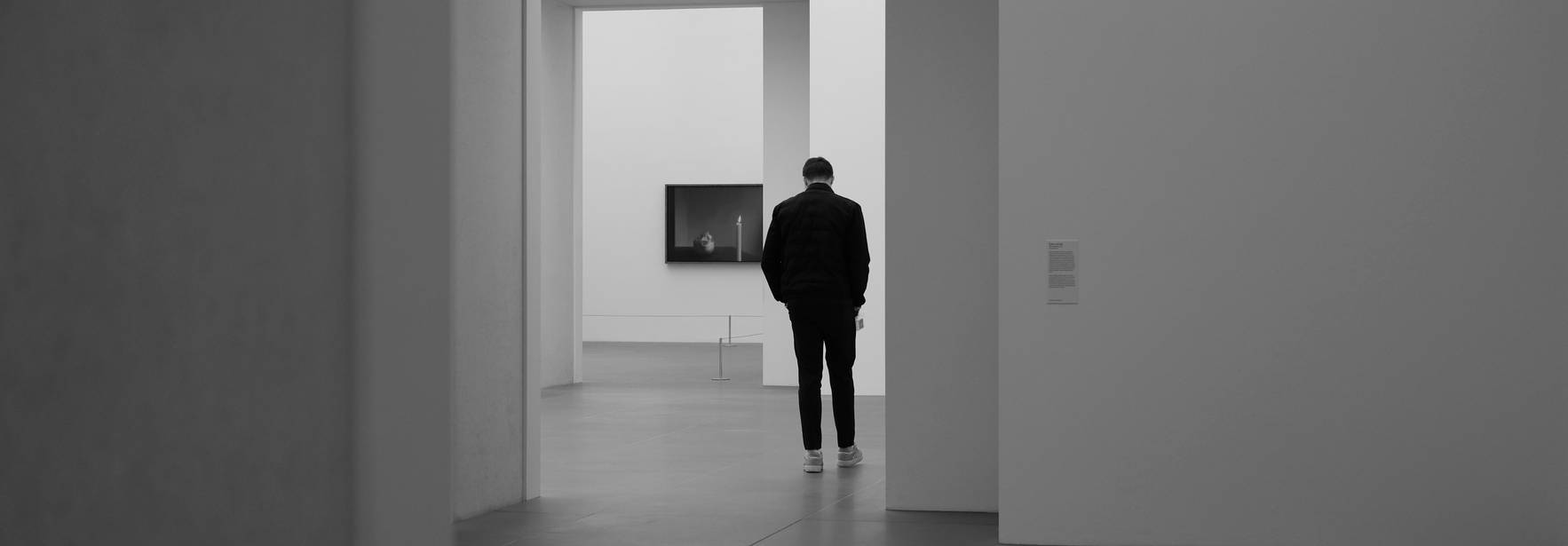 Una persona observa una obra de arte en un museo minimalista.