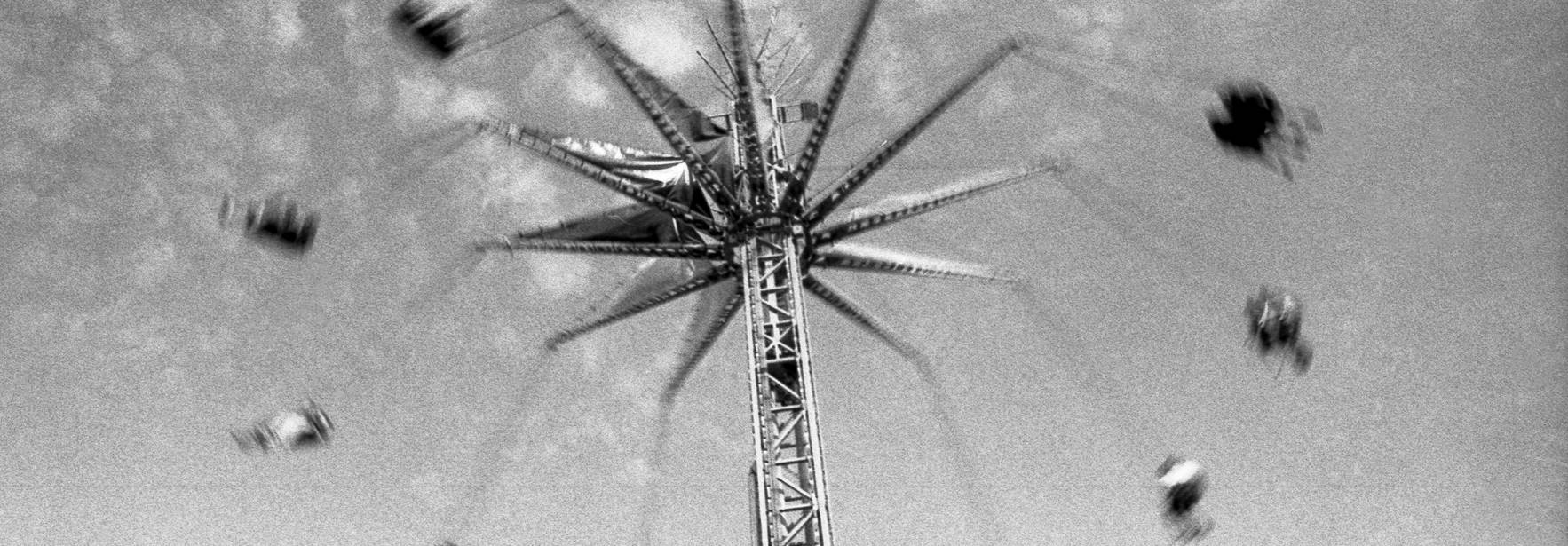 Una noria girando rápidamente en un cielo nublado.