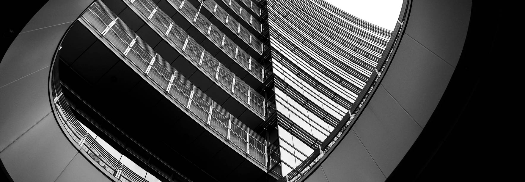 La imagen muestra un edificio moderno visto desde un ángulo inusual, en un contraste de blanco y negro.