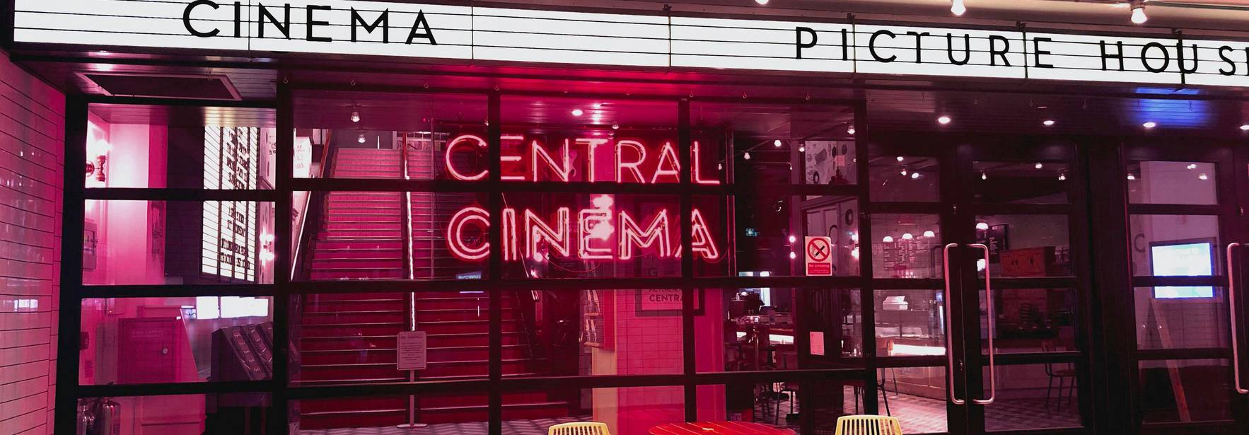 Entrada del Central Cinema iluminada con luces de neón.