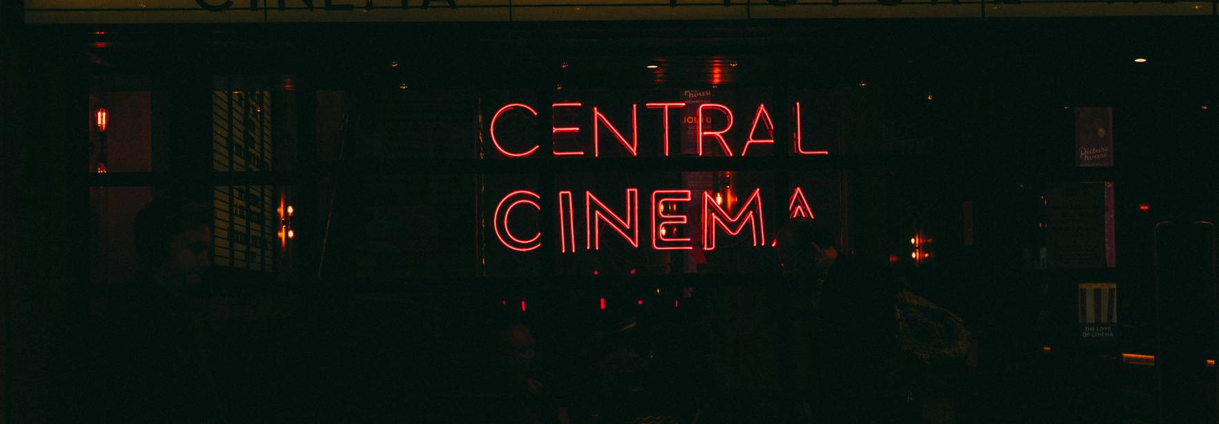 Una fachada de cine iluminada por luces de neón con el nombre 'CENTRAL CINEMA'.