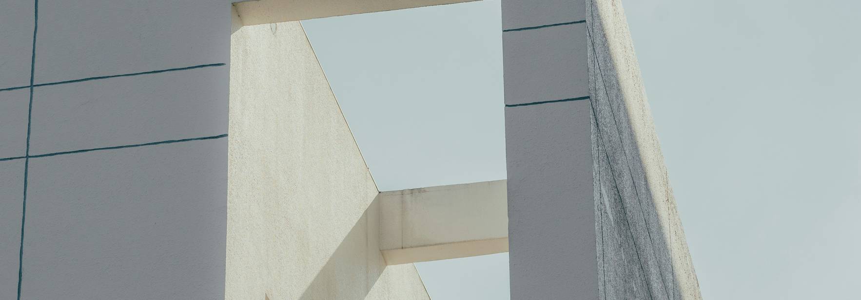 La imagen muestra una esquina de un edificio moderno con un gran marco vacío en la parte superior.