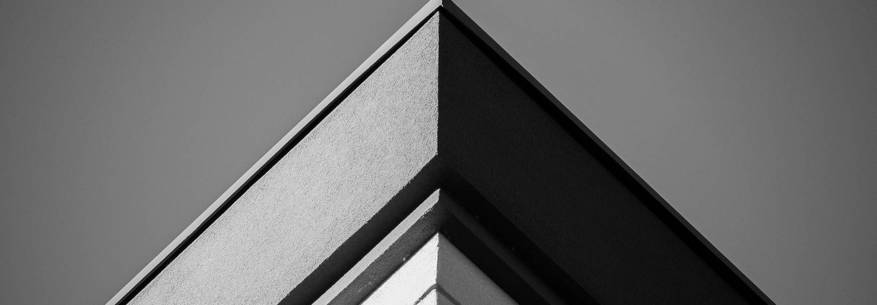 Una esquina arquitectónica en blanco y negro que muestra líneas limpias y angulares.