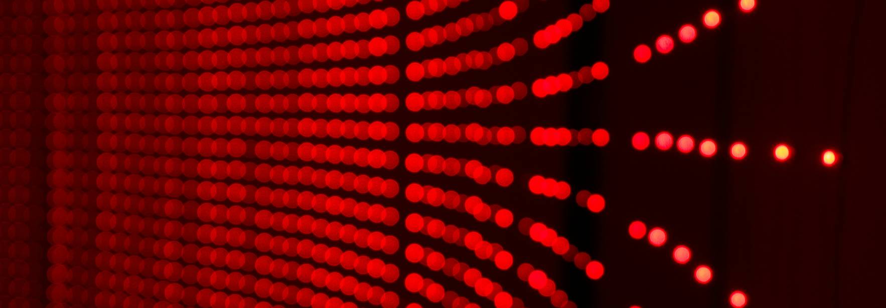 La imagen muestra una pared iluminada por una serie de luces LED rojas que crean un efecto visual atractivo.