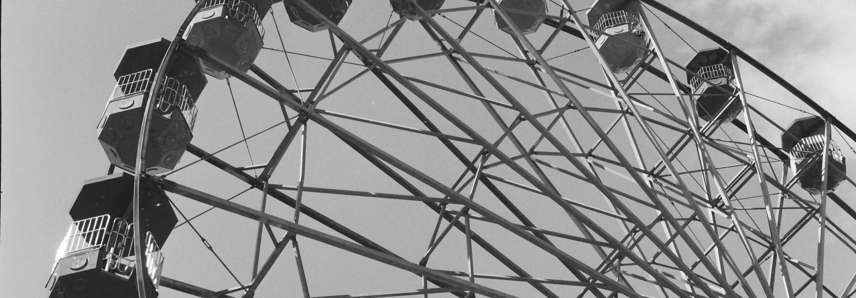 La imagen muestra la parte superior de una noria en blanco y negro.