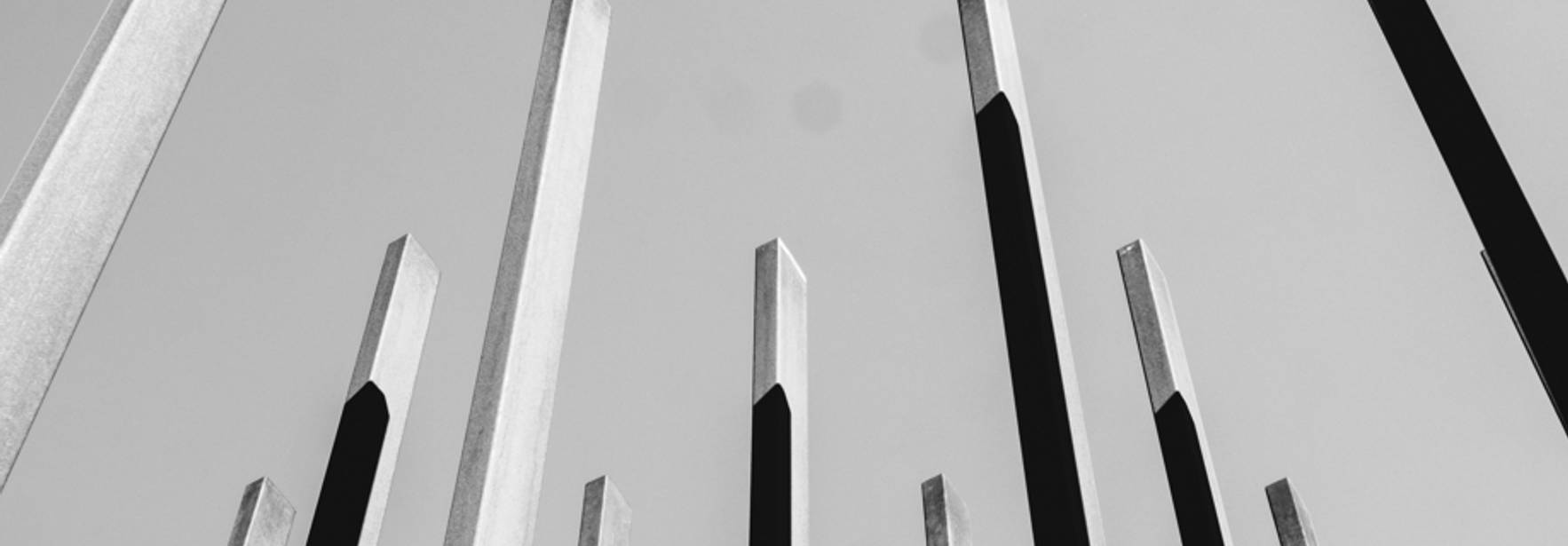 Una serie de estructuras verticales en tonos oscuros y claros que se elevan hacia el cielo.