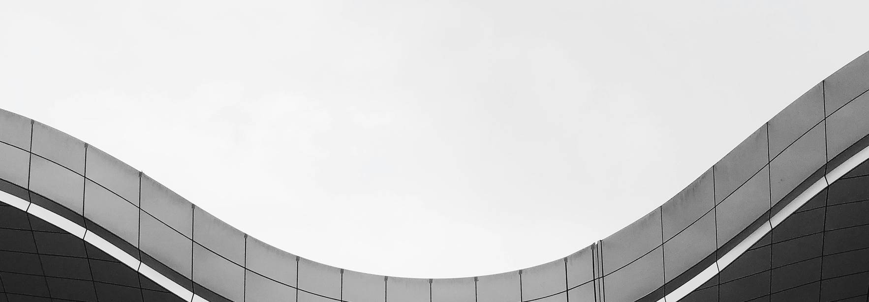 Una estructura arquitectónica moderna con formas onduladas y un diseño minimalista en blanco y negro.