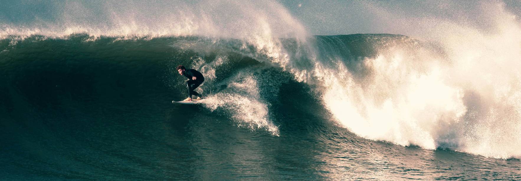 Un surfista montando una ola grande en el mar.