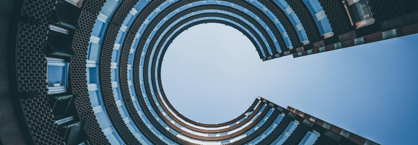 Una vista desde abajo de un edificio en forma de espiral con un cielo despejado de fondo.