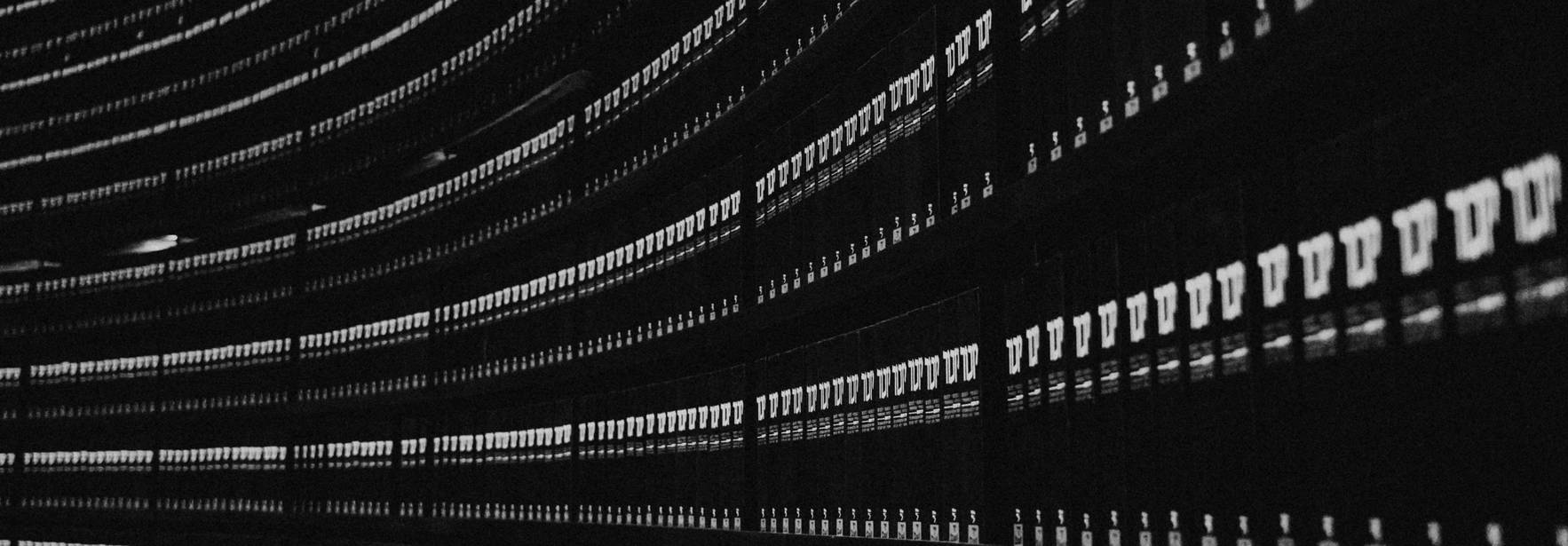 Una vista artística de estanterías llenas de archivos en un entorno oscuro.