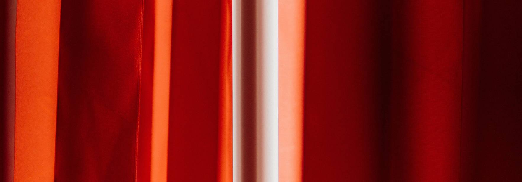 La imagen muestra cortinas rojas que crean un ambiente cálido y acogedor.