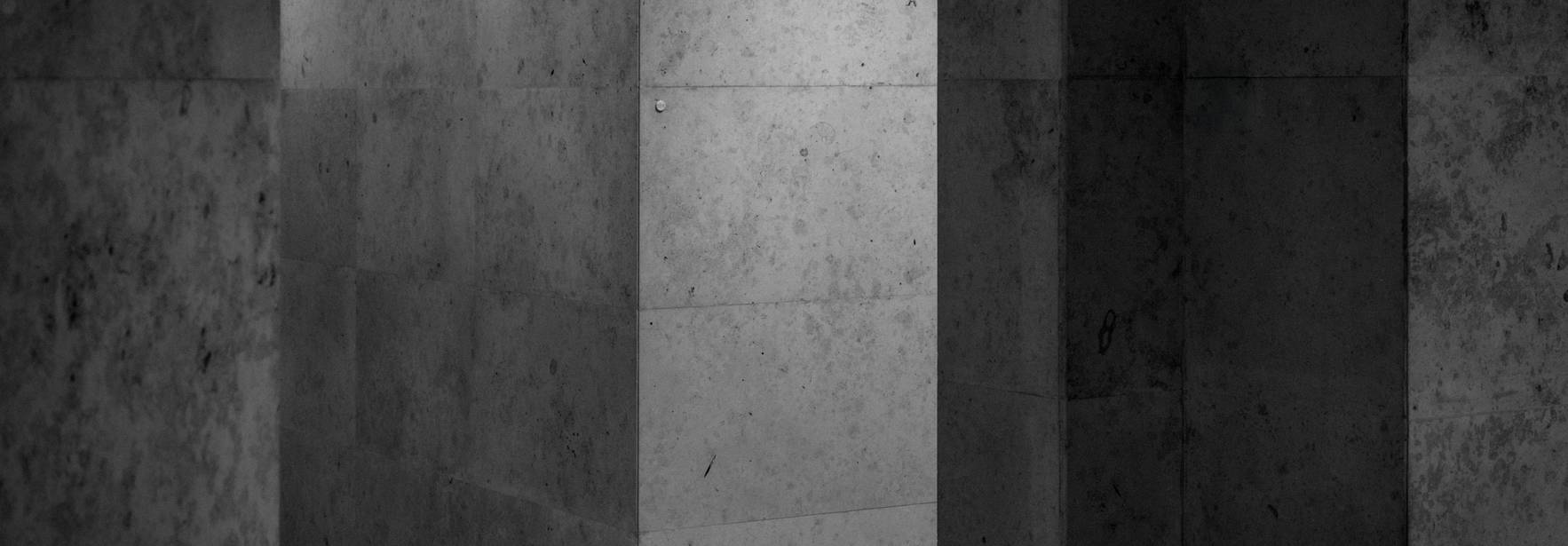 Un pasillo oscuro con paredes de piedra en tonos grisáceos.