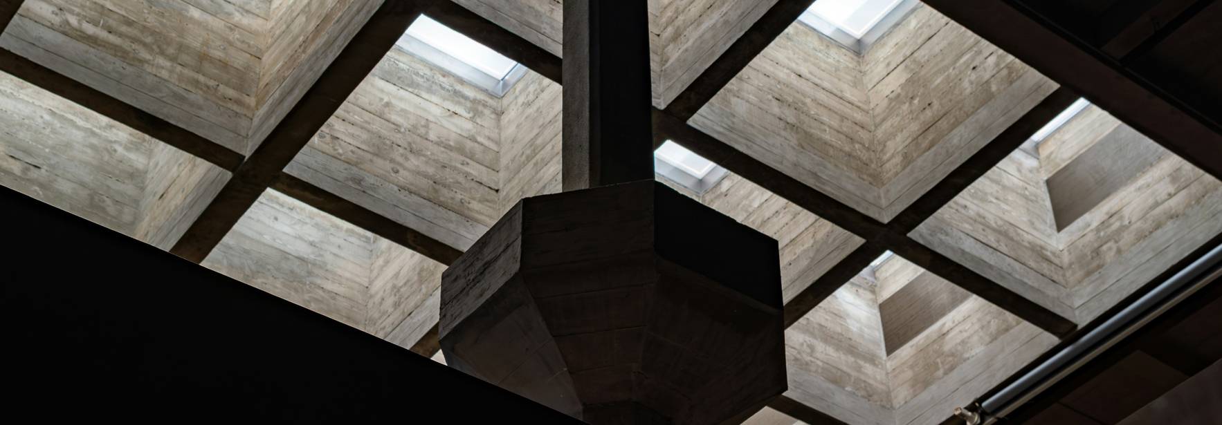 La imagen muestra un techo de concreto con cubos y luces naturales que se filtran a través de las aberturas.