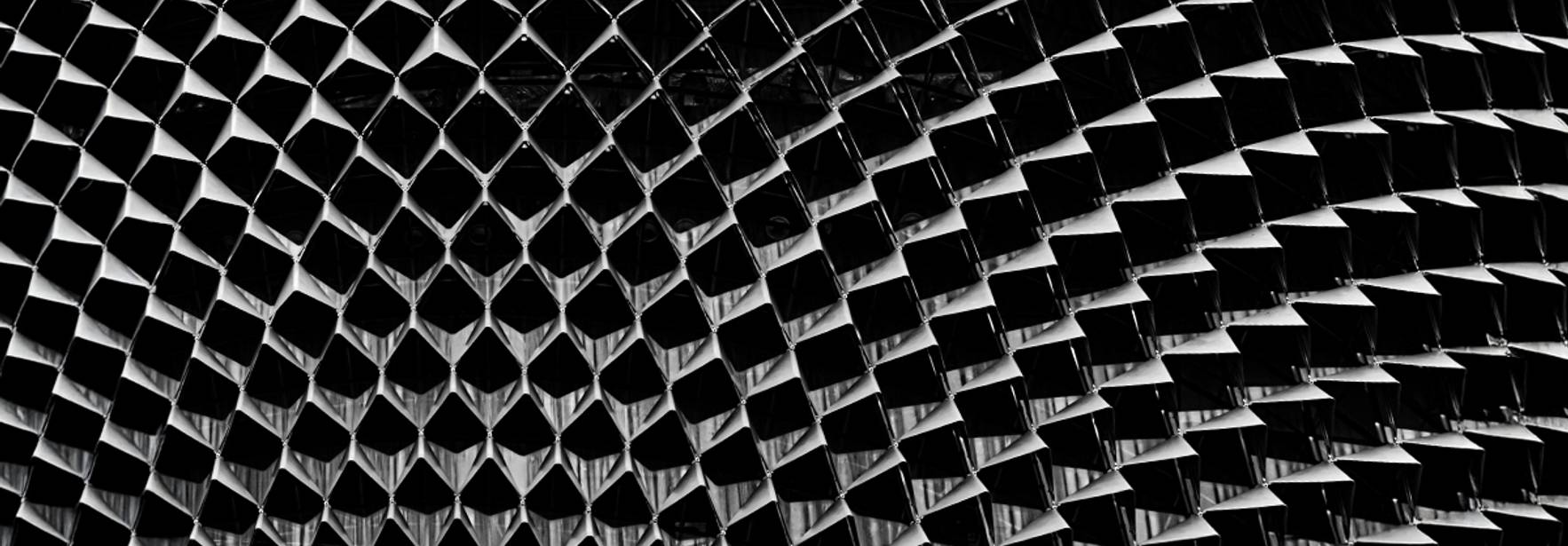 La imagen muestra una estructura arquitectónica con un patrón ondulado en blanco y negro.