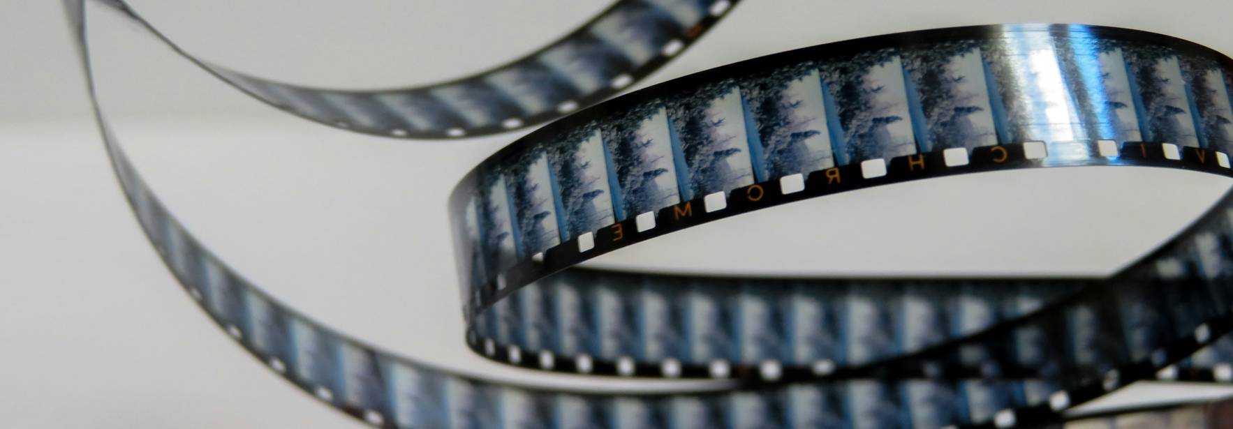 Un rollo de película fotográfica está enrollado y mostrando varias imágenes en tiras.