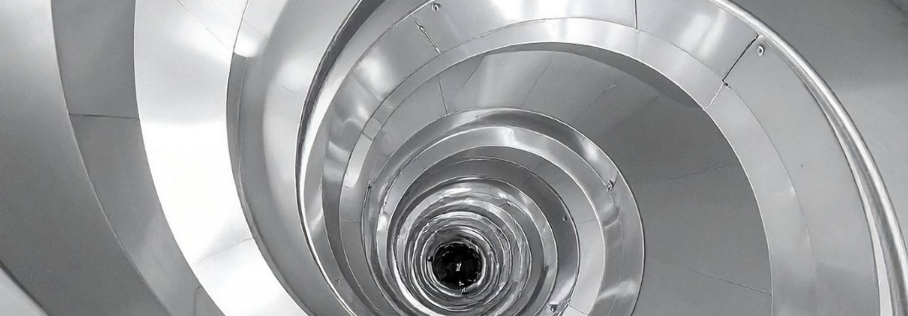 La imagen muestra una espiral metálica que se adentra en un túnel.