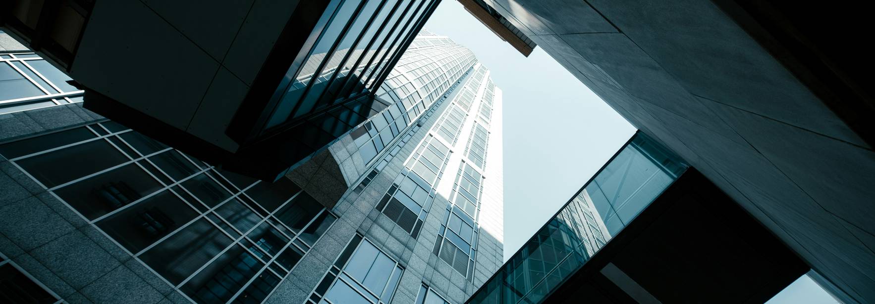 Una vista vertical de un rascacielos moderno entre edificios de cristal.