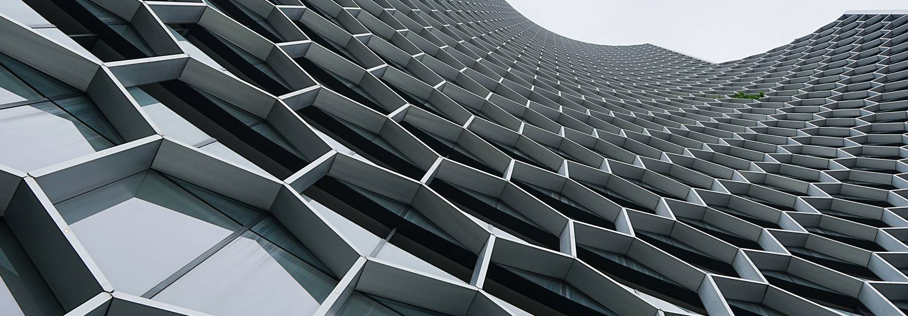 Una vista desde abajo de un edificio moderno con una fachada hexagonal.