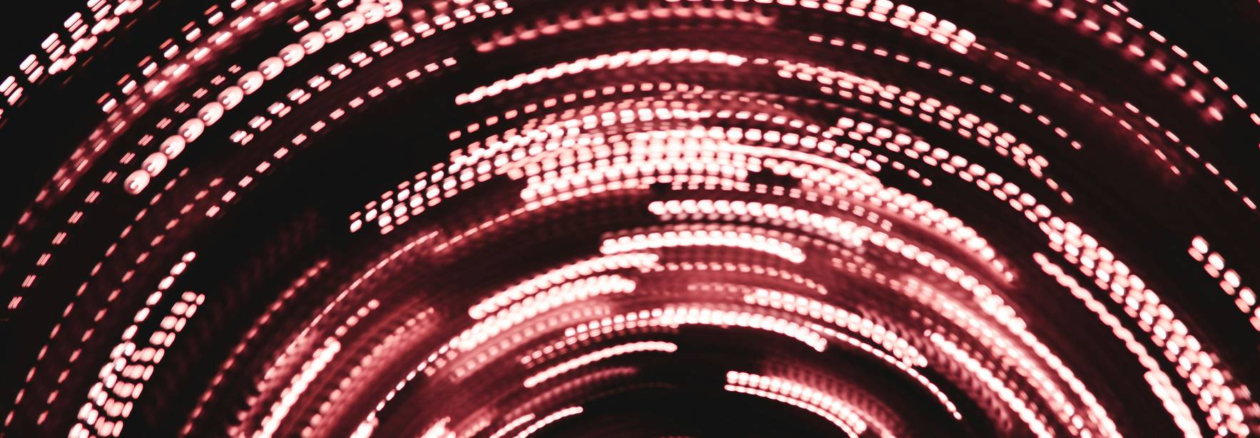 Una imagen abstracta con luces rojas en movimiento que crean un efecto de espiral.