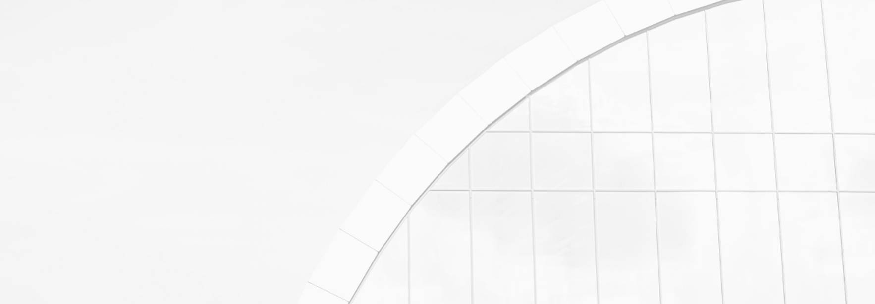 Una imagen minimalista que muestra una estructura arquitectónica blanca con un diseño curvo.