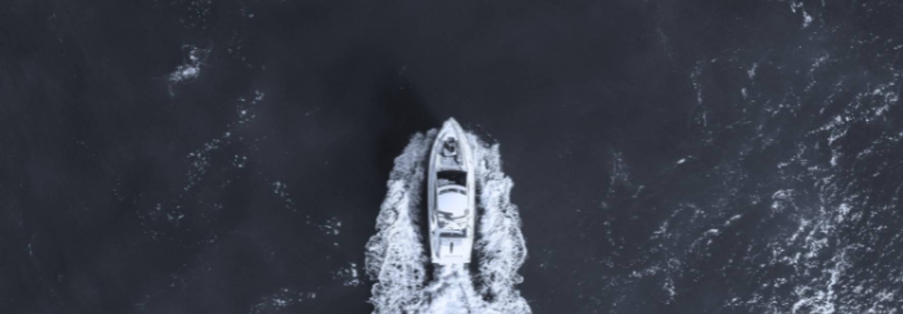 Una vista aérea de un barco navegando sobre un mar oscuro.