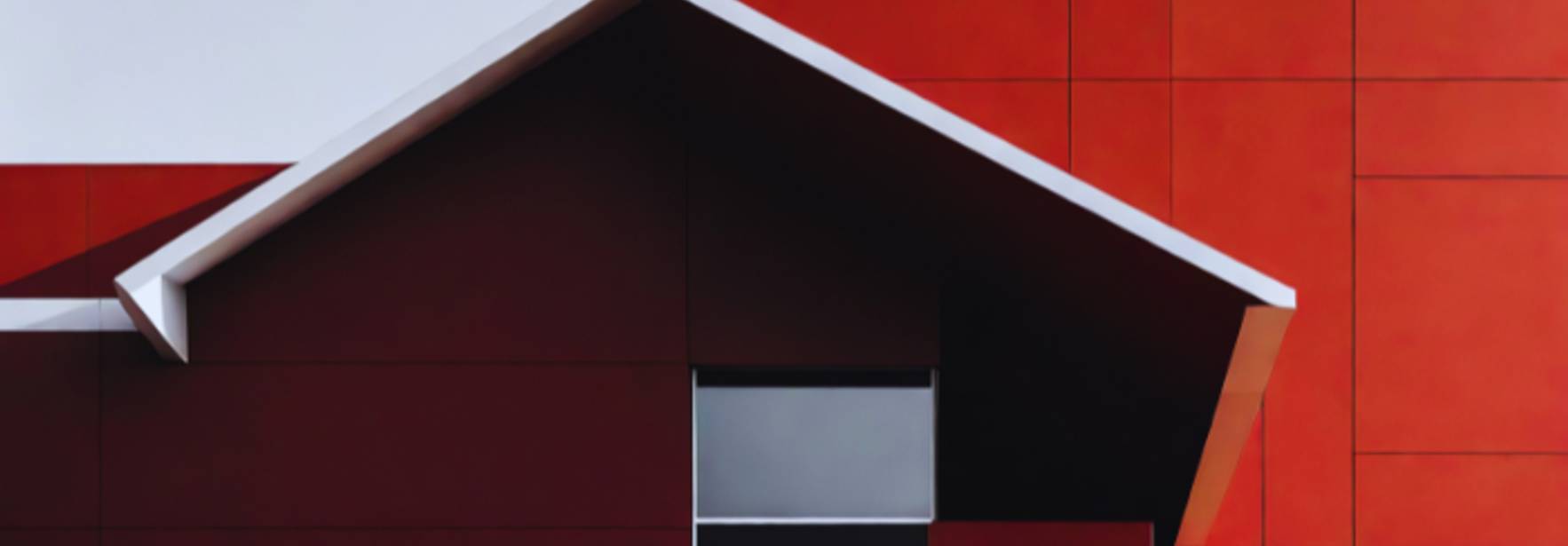 Una fachada moderna con tonos rojos y un diseño arquitectónico angular.