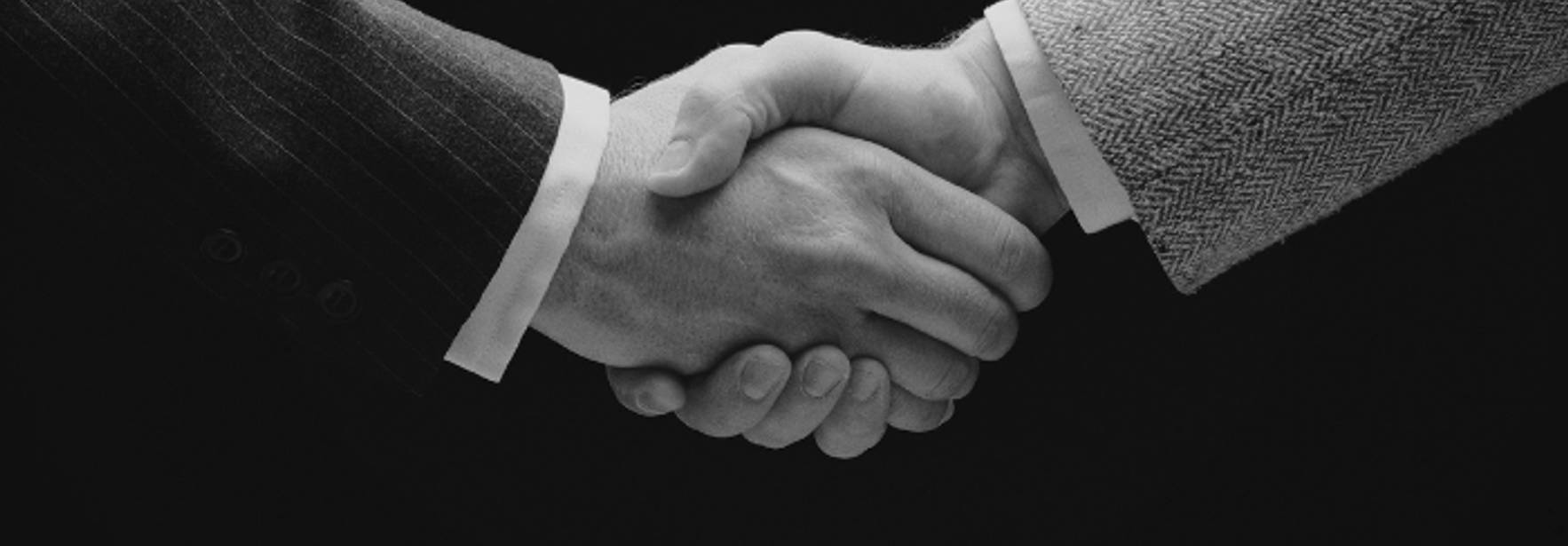 Dos manos se estrechan en un apretón de manos, simbolizando un acuerdo o conexión entre dos personas.