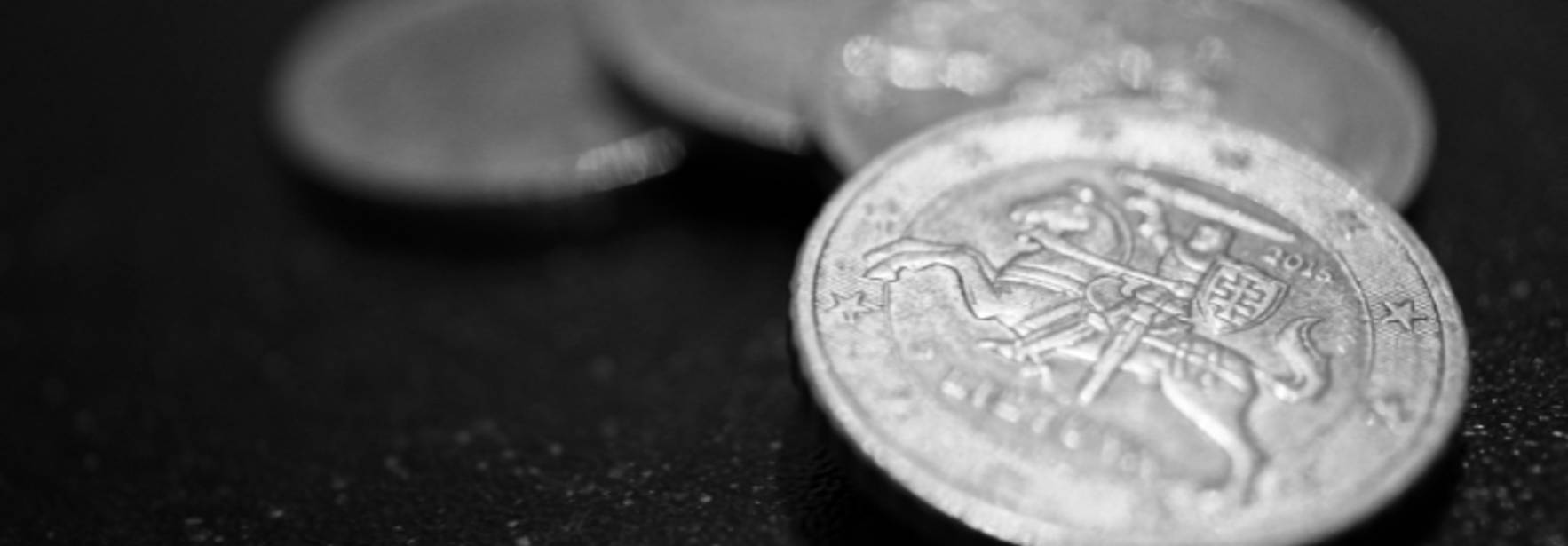 La imagen muestra varias monedas en un fondo oscuro.