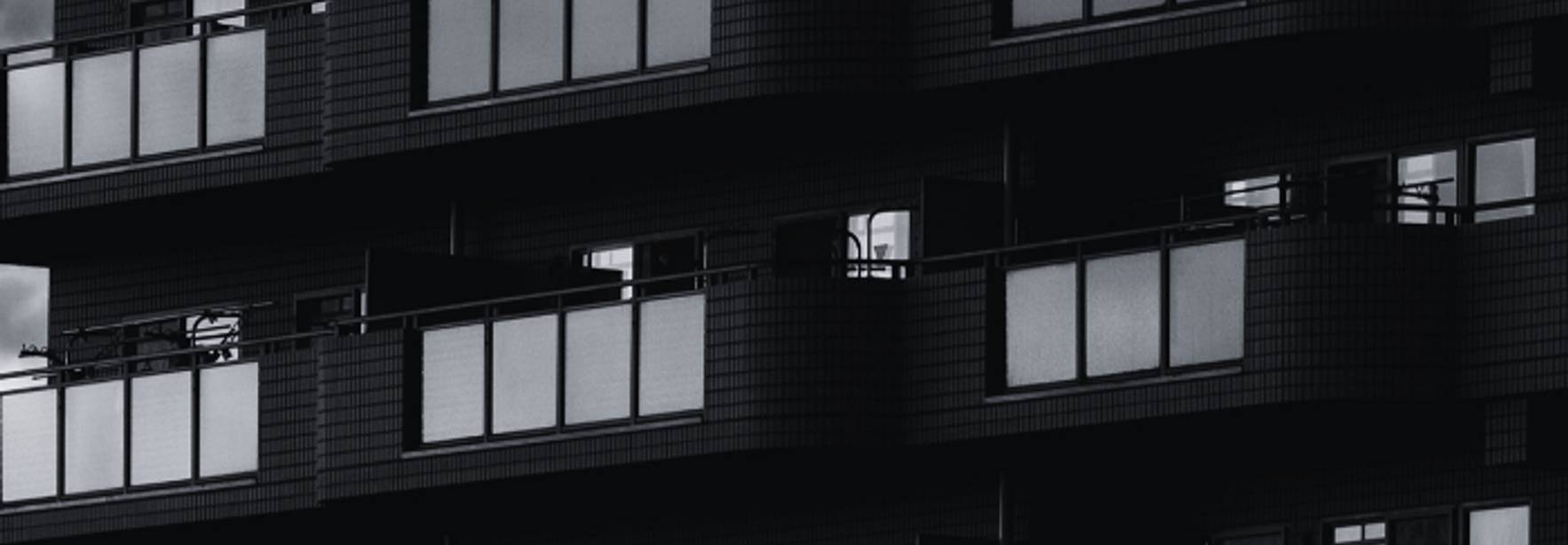 Edificios modernos con balcones y ventanales en tonos oscuros.