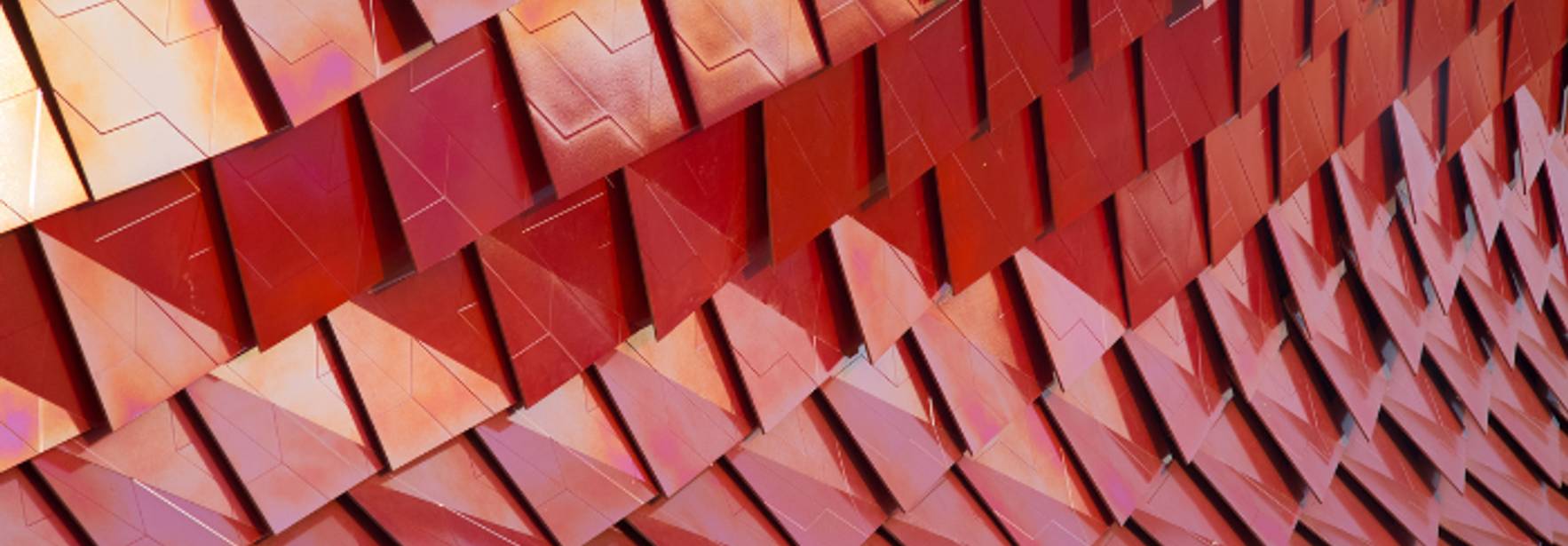 Una superficie compuesta por paneles en tonos rojos que crean un efecto tridimensional.