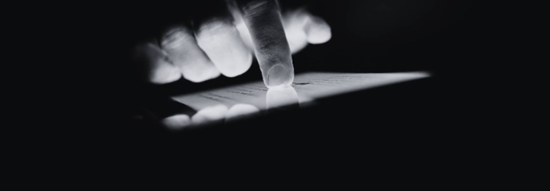 Una mano utiliza un dispositivo luminoso en un entorno oscuro.