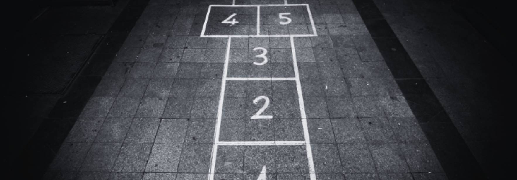 Una serie de cuadros numerados en el suelo, típicos de un juego infantil.