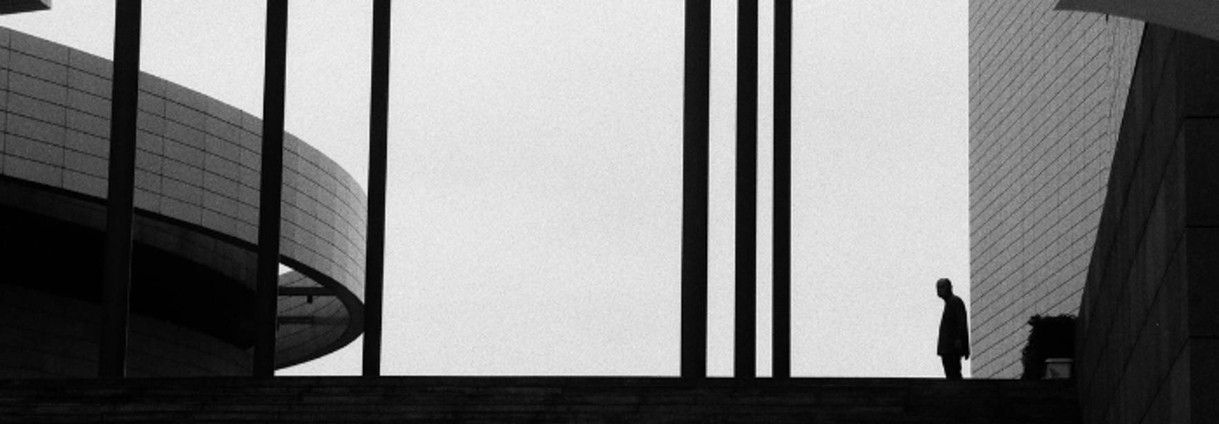 Una figura solitaria se destaca en un paisaje urbano en blanco y negro.
