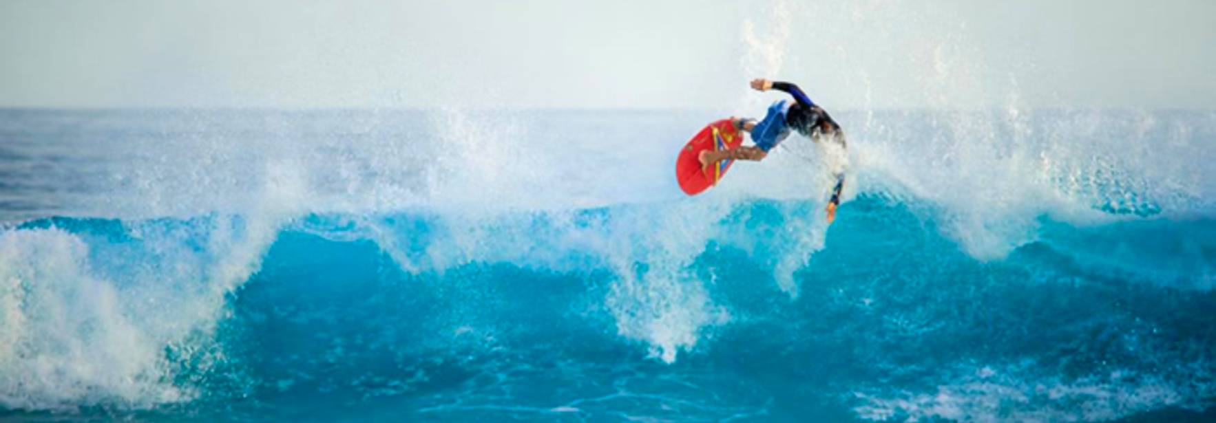 Un surfista realiza un salto sobre una ola en el océano.