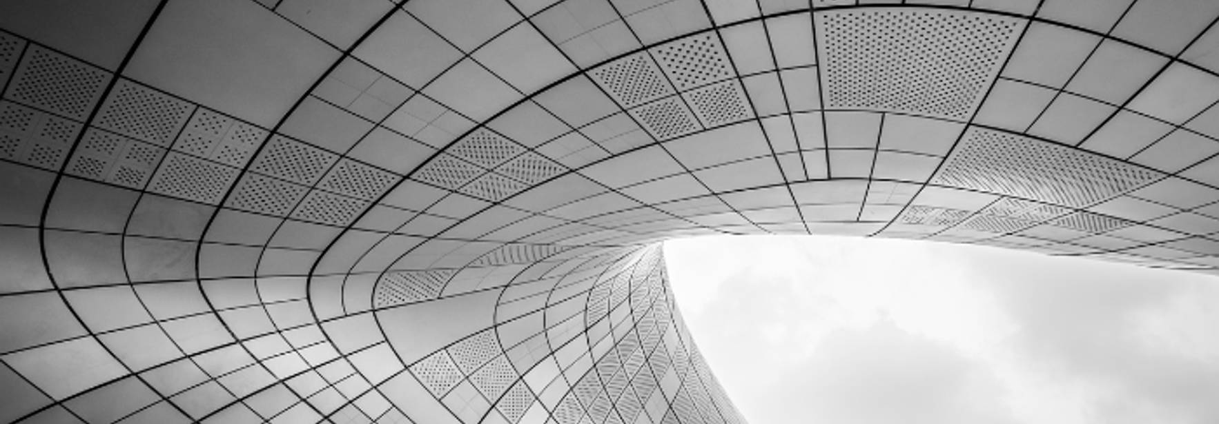 Una estructura arquitectónica en blanco y negro con formas curvas y paneles geométricos.